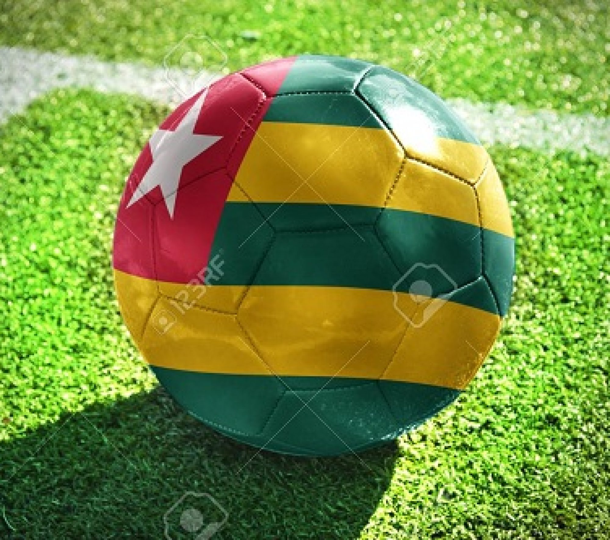 football ball with the national flag of togo lies on the green field near the white line